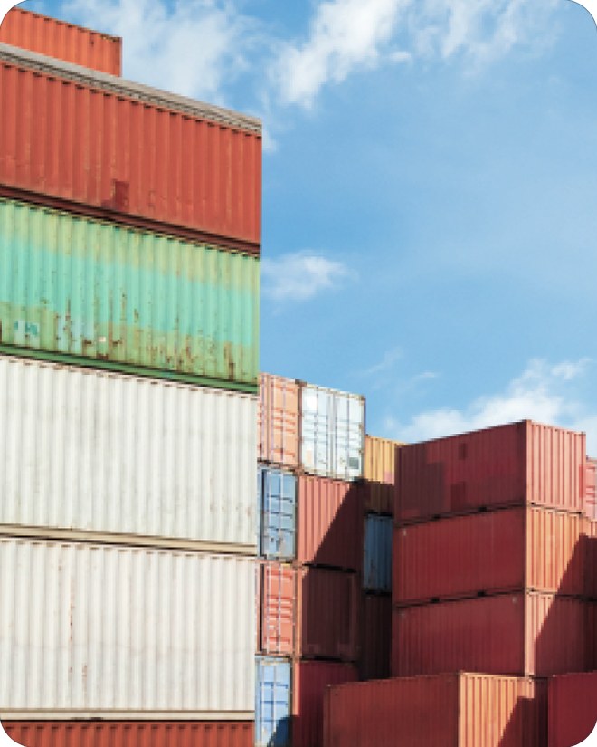 Colorful shipping containers stacked high against a blue sky