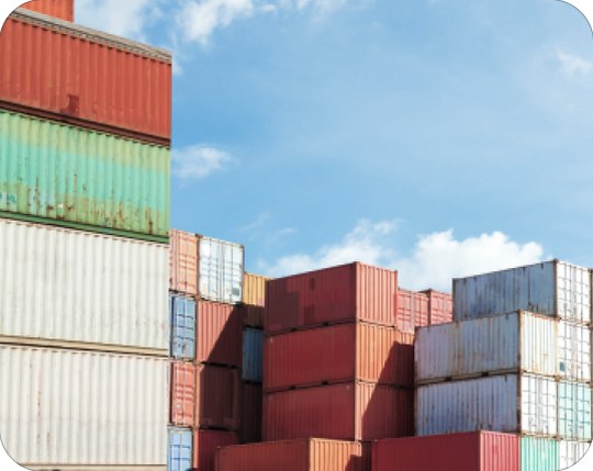 Colorful shipping containers stacked high against a blue sky