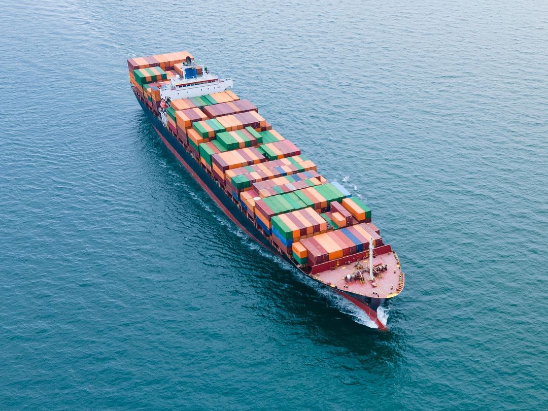 Container ship loaded with cargo sailing across open water