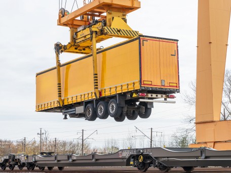 Crane lifting a cargo container onto a rail car